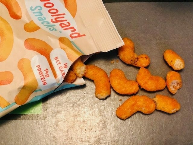 schoolyard-snacks-cheddar-cheese-keto-cheese-puffs spilling onto table- schoolyard snacks reviews-mealfinds