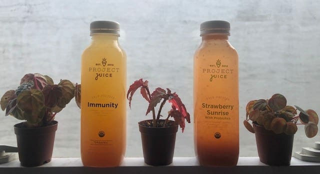 2 juice bottles on window-project juice juice cleanse review-mealfinds