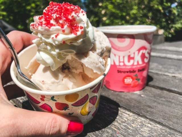 nicks strawbar swirl ice cream in a cup with red sprinkles and whipped cream-nicks ice cream reviews-mealfinds
