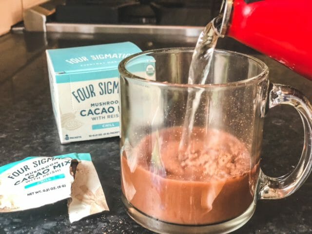hot water poured over mushroom cacao mix in glass-four sigmatic mushroom coffee reviews-mealfinds