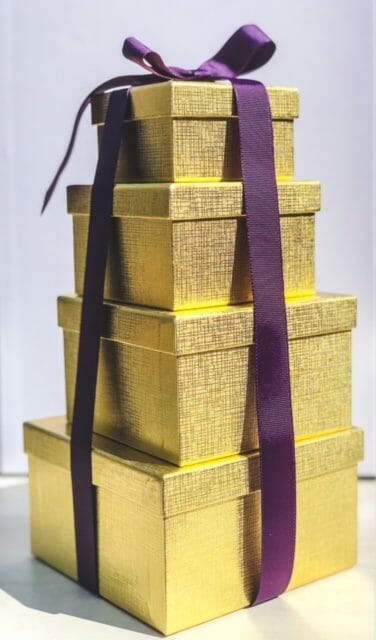 gold boxes stacked with purple ribbon-bake me a wish reviews-mealfinds