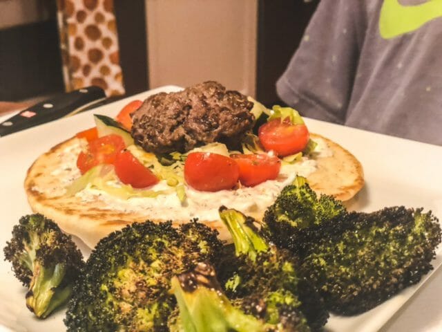 lamburgers with tomato and cucumber in pita on plate with brocolli-eat2explore cooking kit reviews-mealfinds