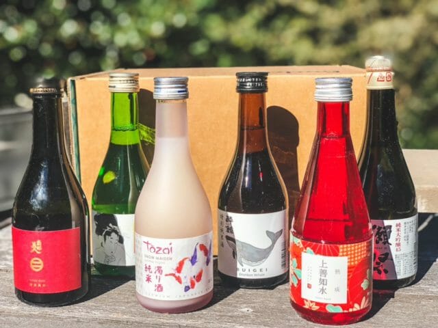 six sake bottles on table-tippsy sake reviews-mealfinds