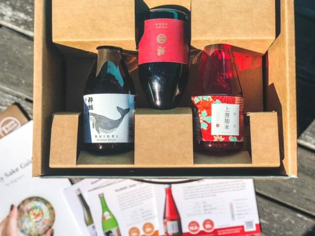 three sake bottles and info cards and guide -tippsy sake reviews-mealfinds