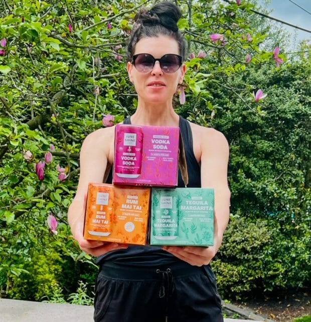 alison holding junshine canned cocktail boxes-juneshine drink review-mealfinds